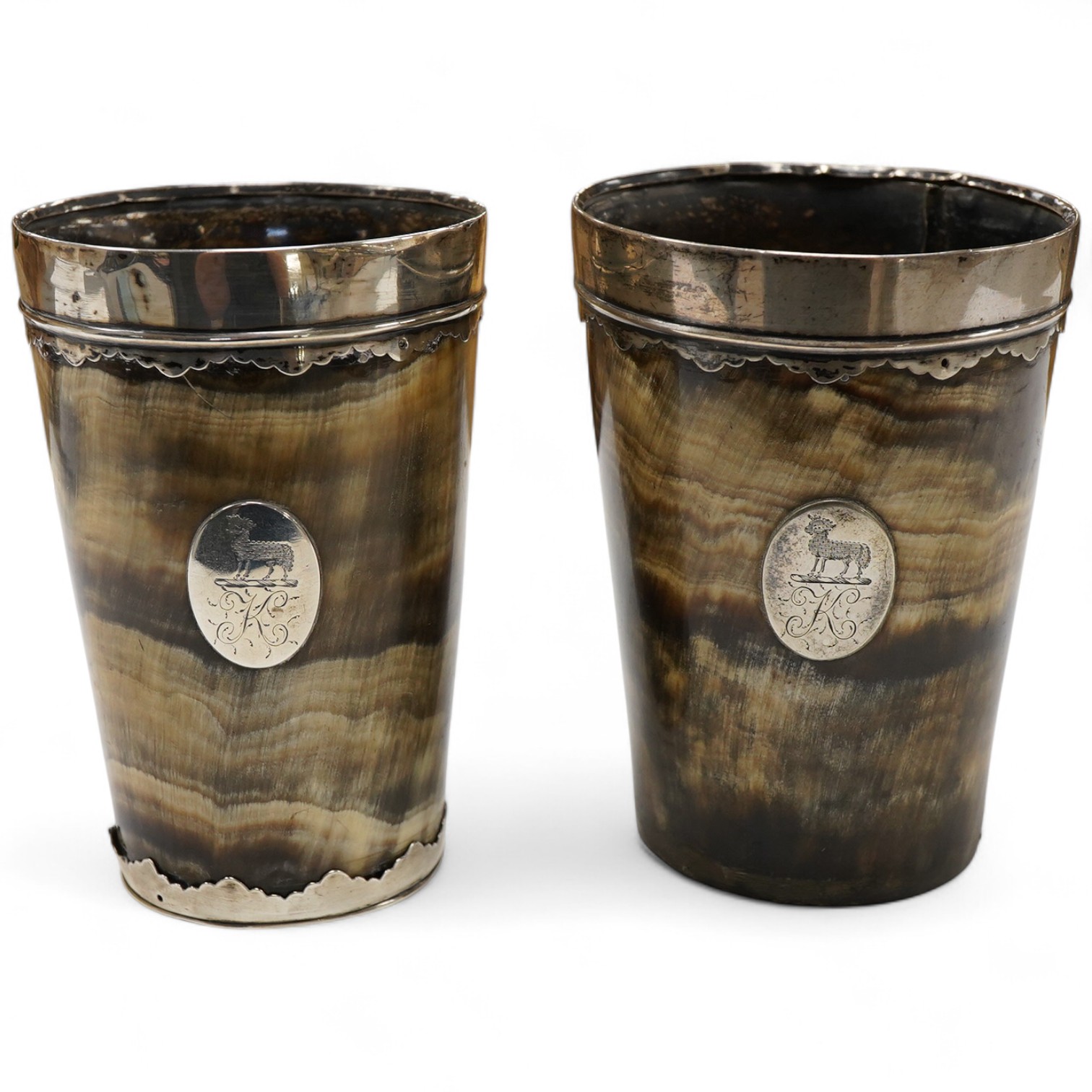 A pair of 19th century white metal mounted horn beakers, with oval appliqués engraved with a sheep and initial, makers mark only IP, one lacking base mount, height 12.5cm.